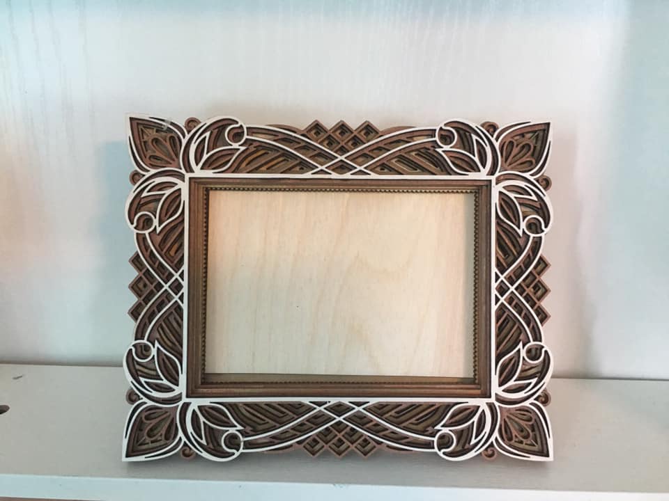 Ornate carved wood picture frame with leaf and lattice detail